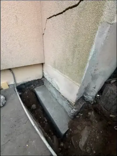 Durante i lavori: Rinforzo delle fondamenta - Muro con crepa: scavo alla base e getto di rinforzo in calcestruzzo, fotografato durante i lavori - RDL Home Service