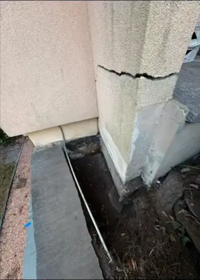 Prima: Rinforzo delle fondamenta - Muro con crepa: scavo alla base e getto di rinforzo in calcestruzzo, fotografato durante i lavori - RDL Home Service